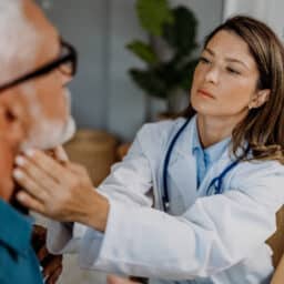 Provider examining a man's throat