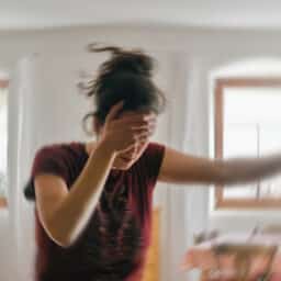 Woman with vertigo holding her forehead through a dizzy spell.