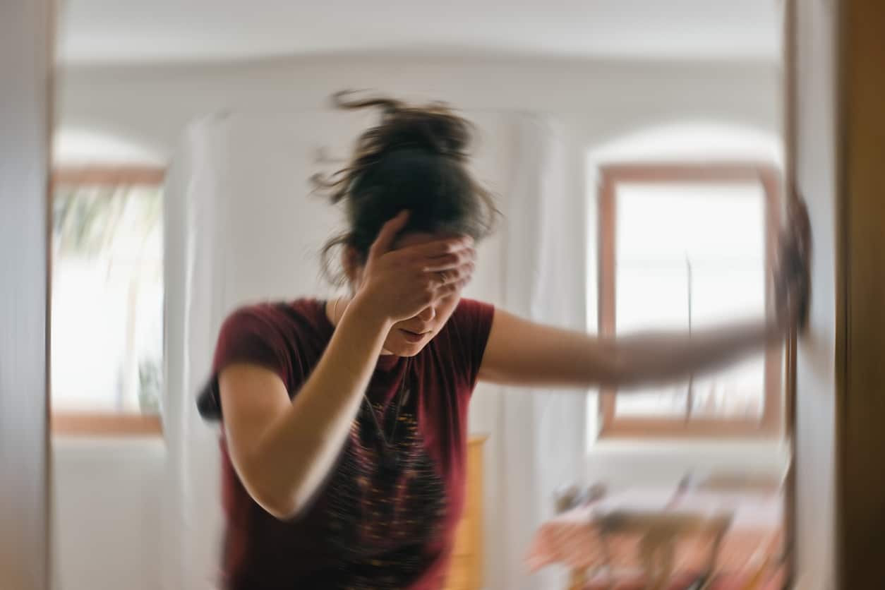 Woman with vertigo holding her forehead through a dizzy spell.