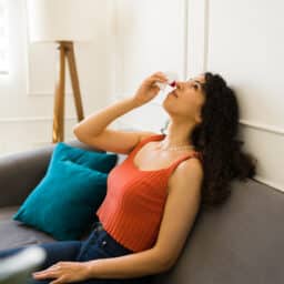 Woman suffering from nosebleed at home