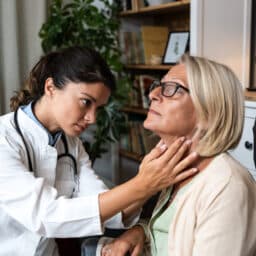 Doctor feeling a patient's throat