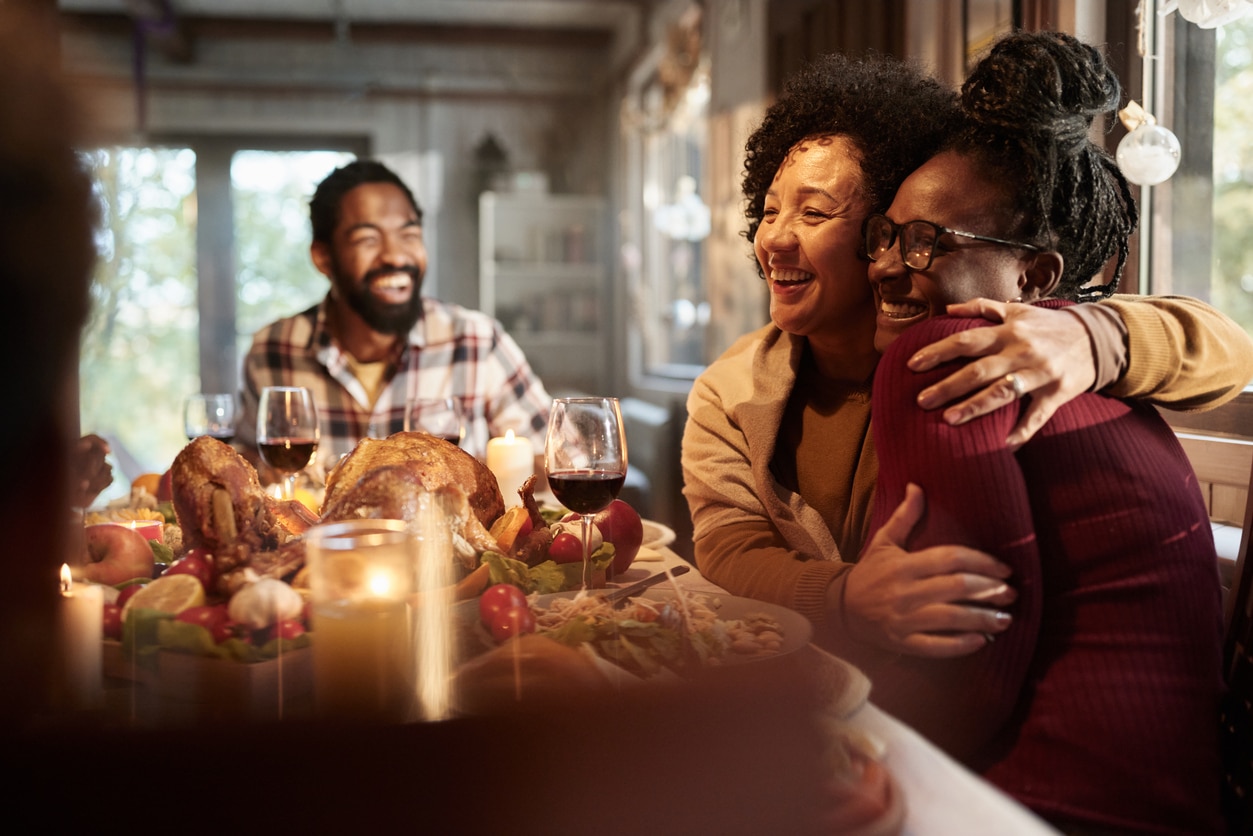 Mother and daughter hugging at Thanksgiving dinner.