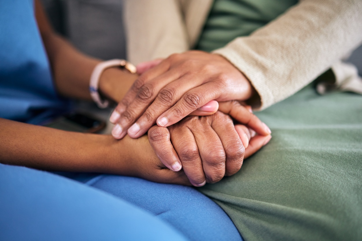 Close up of people holding hands, consoling each other.