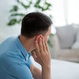 Man holding his ear