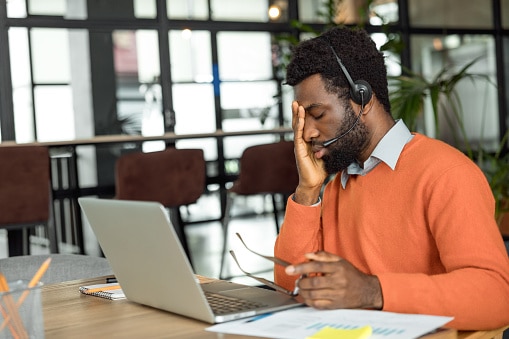 Tired man rubbing his face in exhaustion.