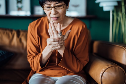 Woman with arthritis holding her sore hand.