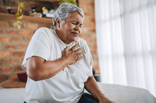 Woman with heartburn putting her hand on her chest.